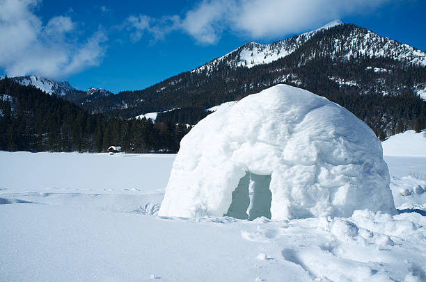 A lone igloo in a mountainous scene Snow igloo in the mountains igloo stock pictures, royalty-free photos & images