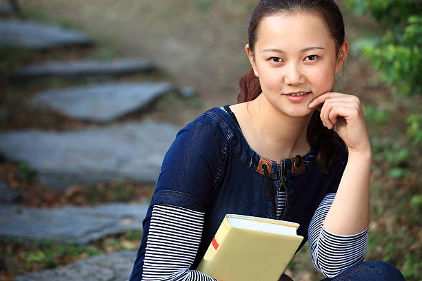 istock Young asian woman reading in the park 155359372
