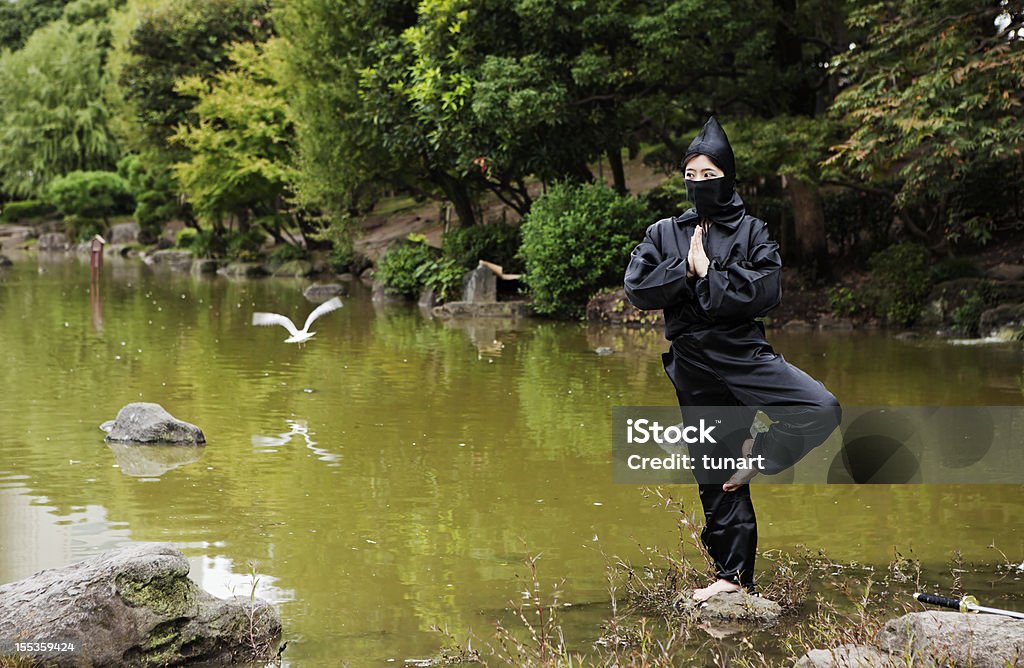 Peacefull Ninja meditating on a stone in a lake, Japan Ninja meditating on a stone in a lake. Ninja Stock Photo