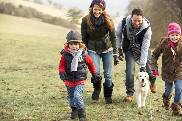 famiglia e cane divertendosi nel paese durante l'inverno - chasing women men couple foto e immagini stock