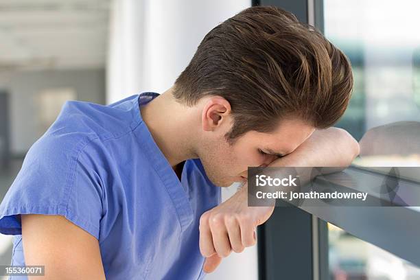 Foto de Jovem Em Azul Esfoliações e mais fotos de stock de Profissional de enfermagem - Profissional de enfermagem, Estagiário, Enfermeiro