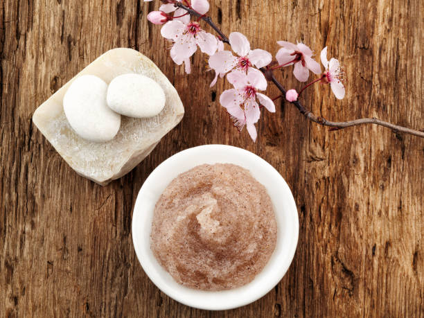 Still life with cherry blossom, salt scrub and white pebbles