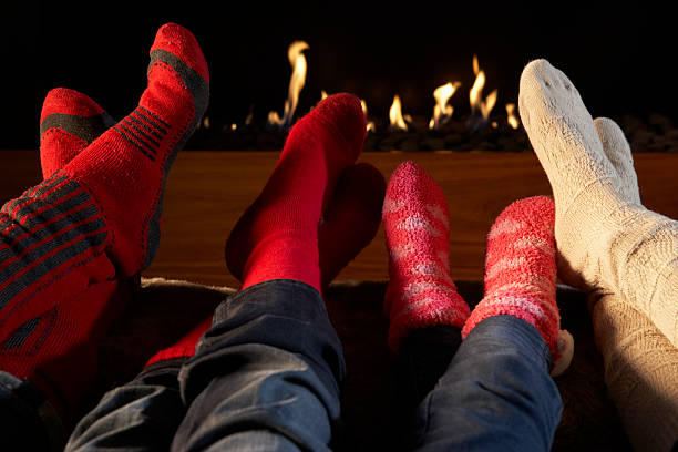istock Four pairs of feet in socks warming by fire 155360160