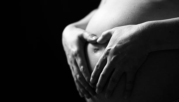 die schwangerschaft - human pregnancy abdomen naked human hand stock-fotos und bilder