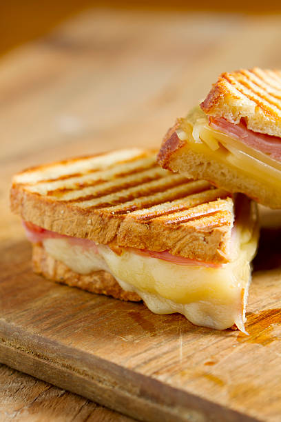 A closeup of a ham and cheese panini sandwich Hot off the grill panini sandwiches made with crusty, hand sliced bread, black forest ham and swiss cheese. panino stock pictures, royalty-free photos & images
