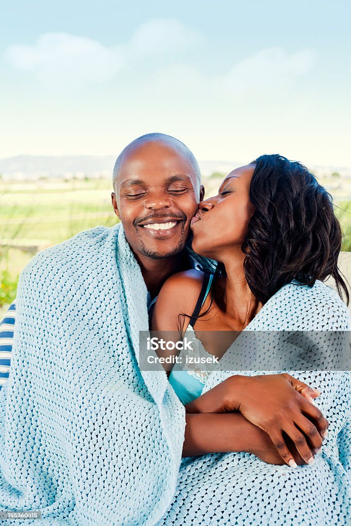 Loving couple Happy couple sitting outdoors, woman kissing her boyfriend. Adult Stock Photo
