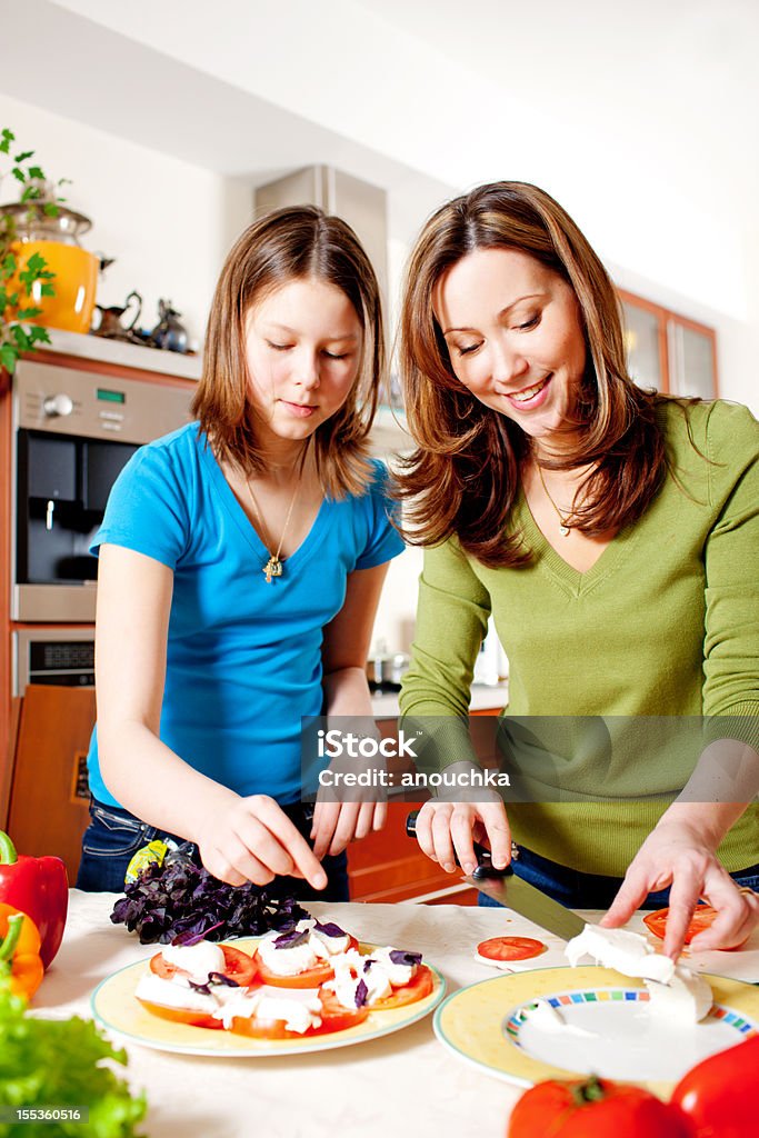 Mère et fille faisant une salade de mozzarella et cuisine - Photo de Mozzarella libre de droits