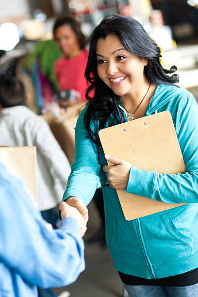 istock Young woman greating customer at a donation center 155360644