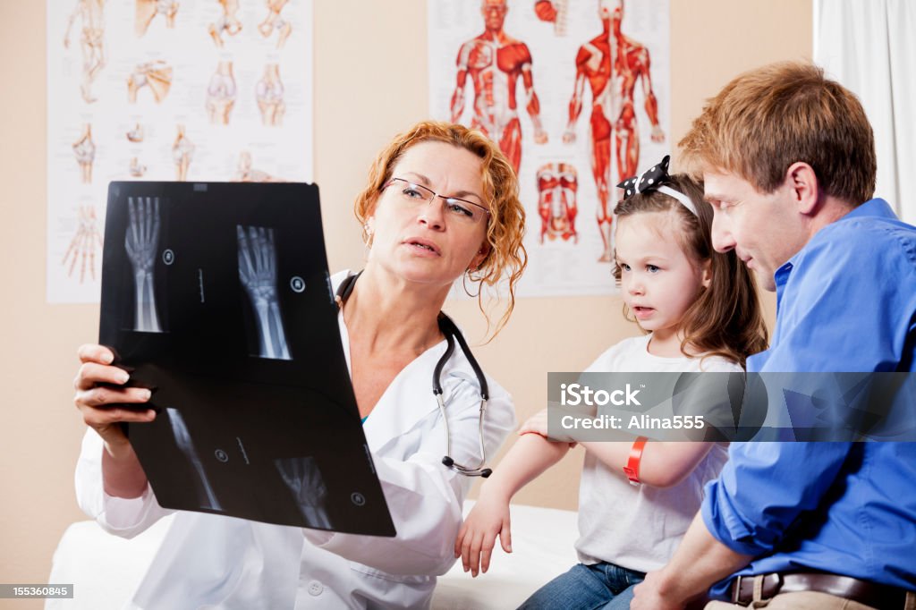 Médico explicando raios X de mão para um pai da menina - Foto de stock de Imagem de raios X royalty-free