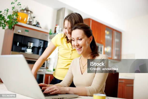 Feliz Mãe Com Menina Usando Computador Portátil Em Casa - Fotografias de stock e mais imagens de 12-13 Anos