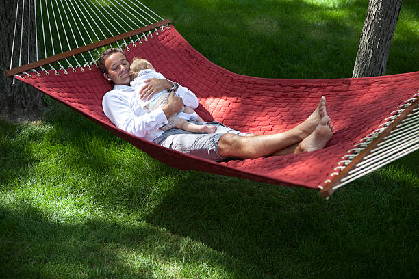 istock Baby Boy And His Father Relaxing In A Hammock 155360906