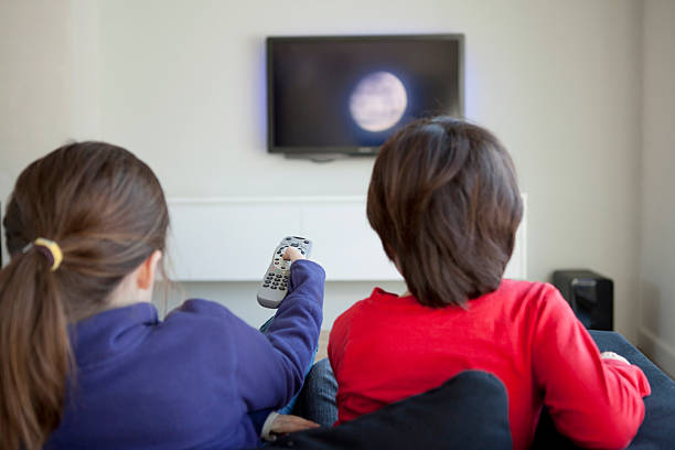 Children changing the television channel stock photo