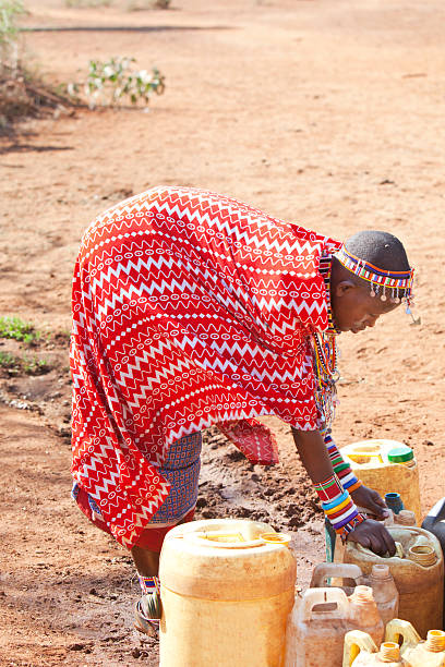 istock Young masai woman collecting water 155361378