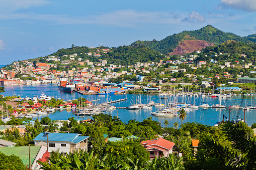 Commercial and tourist docks of St. George's. This beautiful city, capital of Grenada, faces a horseshoe-shaped harbor called The Carenage, and is surrounded by a hillside of an old volcano crater. Built by the French in 1650, St. George's has a waterfront lined with elegant colonial buildings and colorful Caribbean style dwellings, with restaurants, bar and shops.