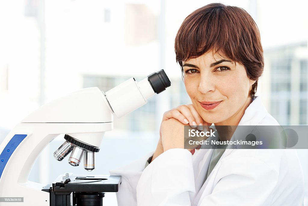 Smiling Female Pathologist Portrait of a smiling female pathologist at her desk with microscope. Horizontal shot. 30-39 Years Stock Photo