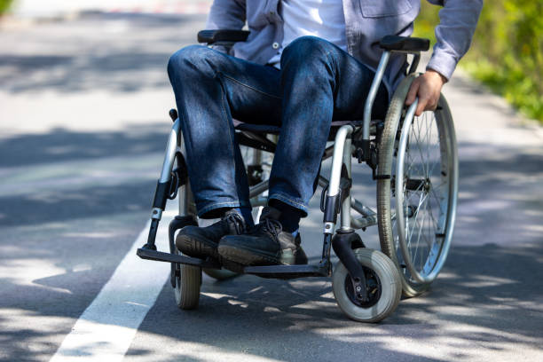 istock Unrecognizable man on wheelchair in park. 1553614715
