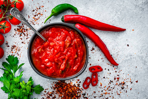 istock Red hot chili sauce with ingredients shot from above on gray table 1553623685