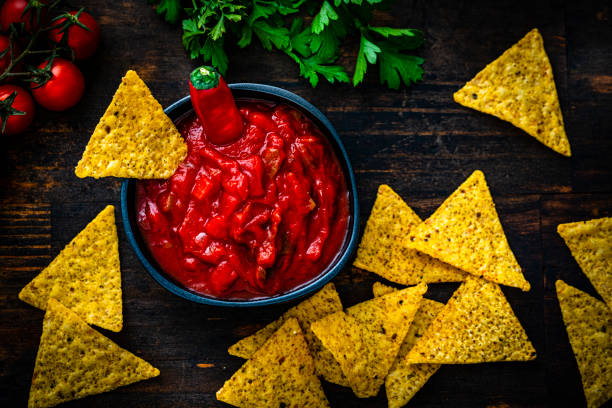 istock Mexican food: salsa and nacho chips shot from above on dark wooden table 1553624207