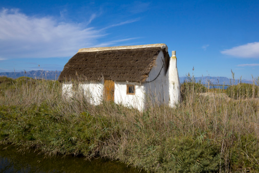 Typical hut of rice cultivated land in Montsià, Delta de l'Ebre, Tarragona, Catalonia, Spain. The roof is made of rice straw.