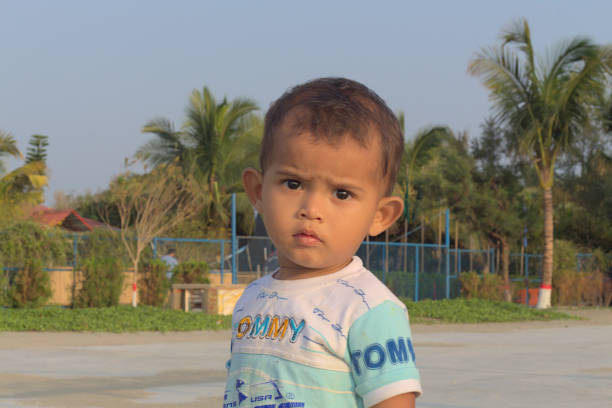 Elementary age boy sitting portrait near brahma sarovara in holy land of kurukshetra during casual festival.