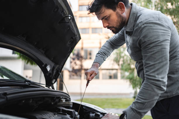 istock White man trying to repair his car after breakdown 1553664943