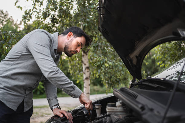 istock White man trying to repair his car after breakdown 1553665490