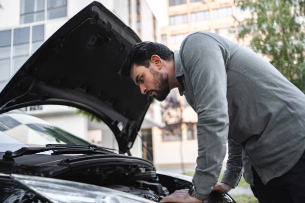 istock White man trying to repair his car after breakdown 1553665496