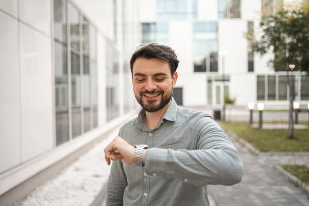 istock White businessman using smart watch in front of his office building 1553666050