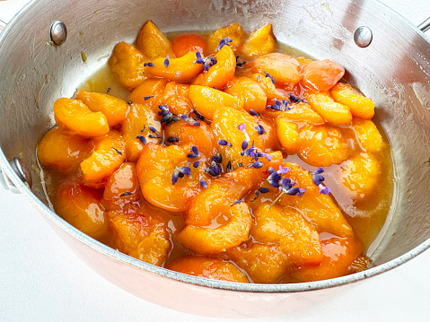 close-up of fresh apricots caramelizing in pan with lavender