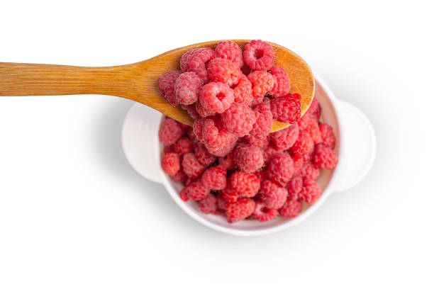 istock Pour fresh berries with a wooden spoon into a white bowl. 1553668894