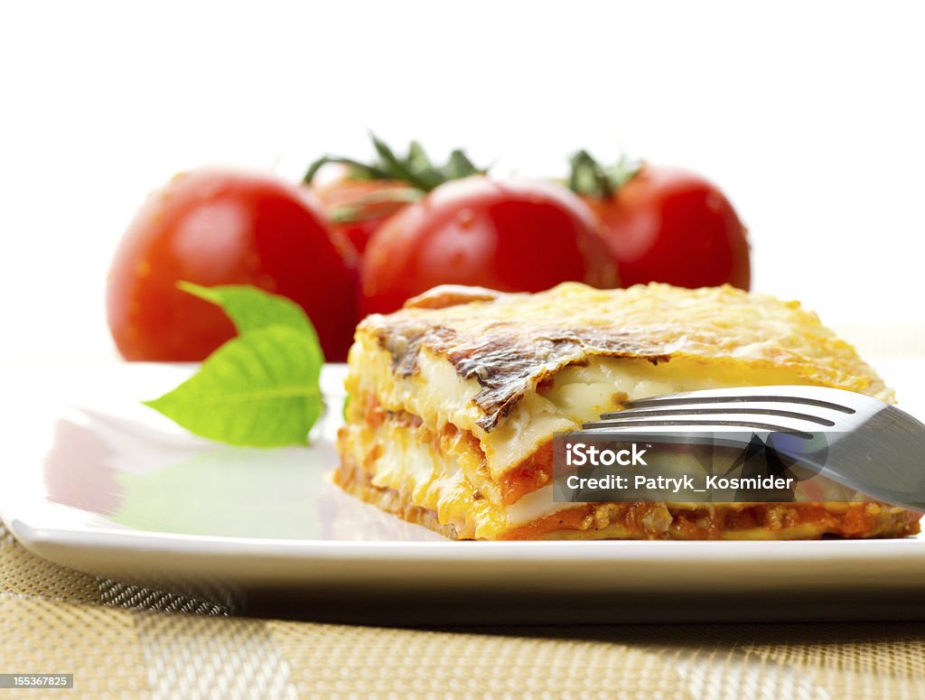 Italian lasagna dish Italian lasagna dish with fork and fresh tomatoes Baked Stock Photo