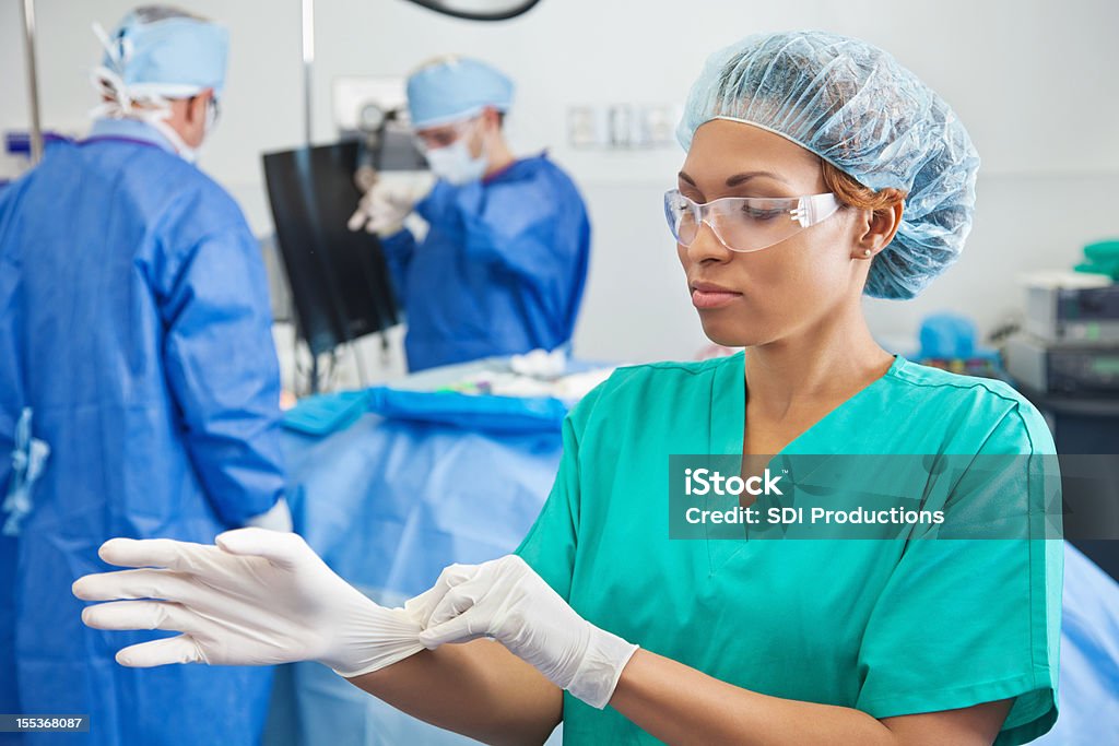 Nurse putting gloves on preparing for surgery Nurse putting gloves on preparing for surgery.   Getting Dressed Stock Photo