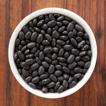 Top view of white bowl full of black beans