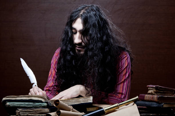 istock Medieval philosopher with long hair and beard writing on desk 155368394
