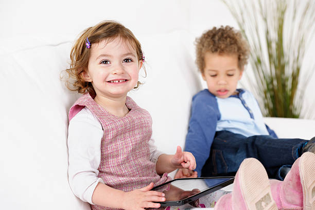 istock Caucasian Toddler/ Girl Little Using Digital Tablet While Peer Snoozes 155368572