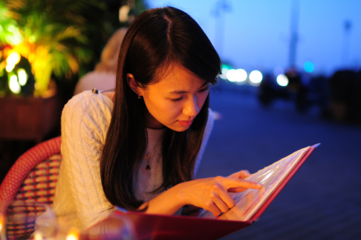 Young  woman is looking menu at restaurant
