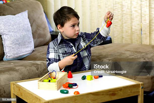 Boy Threading A String Of Beads Stock Photo - Download Image Now - Child, Coordination, Bead