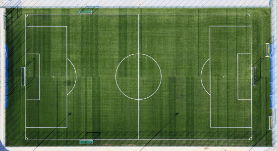 Rugby field top straight down aerial shot. Empty football playground. Sport stadium green grass and white paint lines and marks for games and activity. Healthy lifestyle.