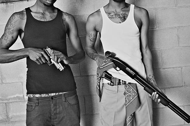 deux gang membres avec armes à feu - gangster photos et images de collection