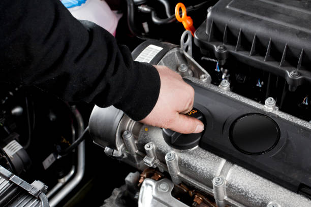 istock Auto mechanic opens/closes engine oil filler cap 155369284