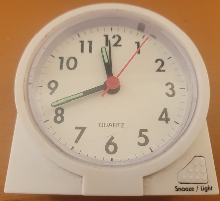 A white quartz alarm displays the time 11:42.
