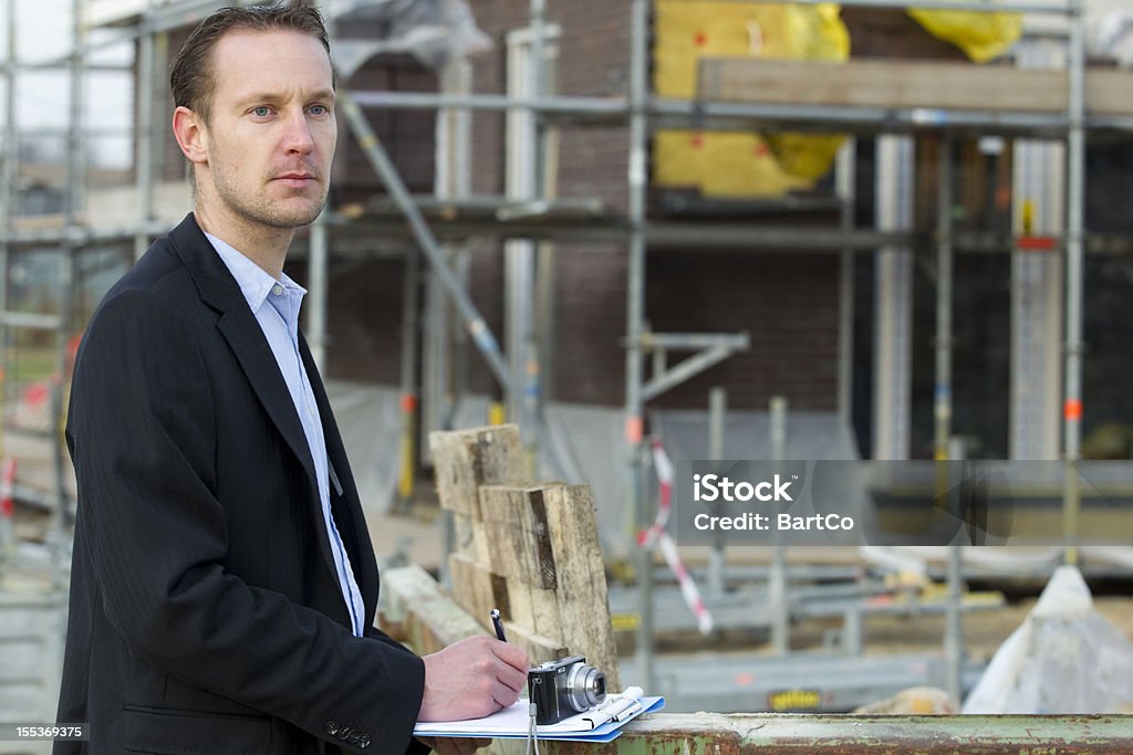 Homem de terno faz a cotação para uma renovação - Foto de stock de Corretor de Imóveis royalty-free