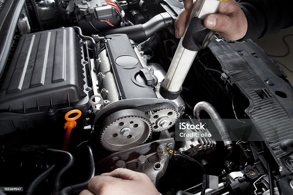 Mecánico está revisando el momento para cinturón de un coche moderno - Foto de stock de Garaje de reparación libre de derechos