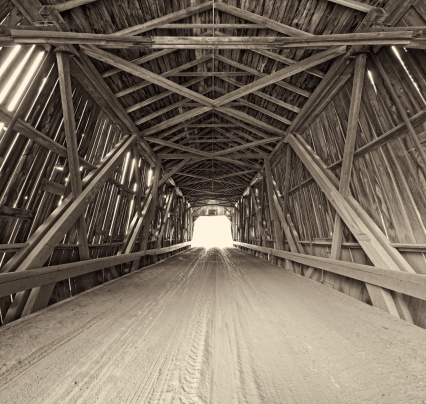 Standing in the middle of a covered bridge.  Toned black and white, stitched images.