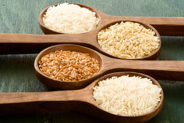 istock Four wooden spoons holding different types of rice 155369614