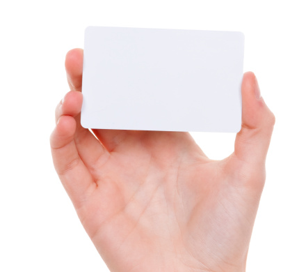 Woman`s hand holding a blank business card on white background. Close up horizontal studio shot 