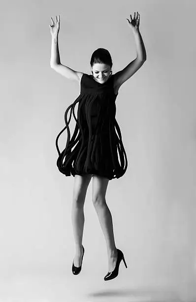 A fashion model strikes jumps in a vintage Avant- Garde dress from the 1960s