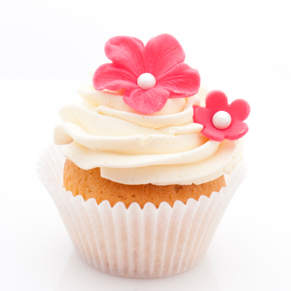 Vanilla cupcake with red sugar flowers on white background, studio isolated.