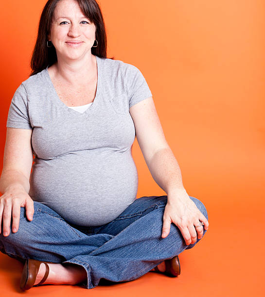 istock Pregnant Women Isolated on Orange Background 155370441