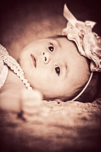 Adorable baby girl playing with his legs portrait
